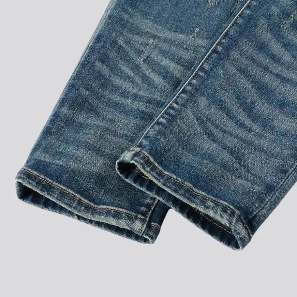 Medium-wash men's black-patch jeans