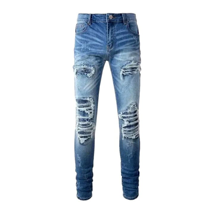 Damaged men's whiskered jeans